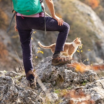 man and cat on a mountainside